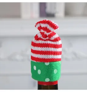 Detail view of red striped knit and green polka dot Christmas wine bottle decoration