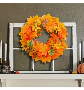 Vibrant autumn door wreath featuring realistic maple leaves and mini pumpkins on white window