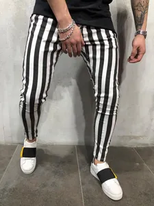 Detailed view of men's slim fit trousers with bold black and white vertical stripes
