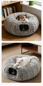 Detail van grijs langharig pluche tunnelbed voor katten met gezellig interieur en speelbal