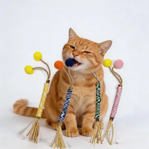 Cute ginger cat biting a natural silvervine chew stick toy for pet dental care.