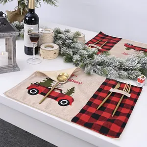 Festive Christmas placemats with red and black plaid and cartoon truck design on table.