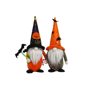 Dos gnomos de Halloween con sombrero de calabaza sosteniendo murciélago y bastón dulce