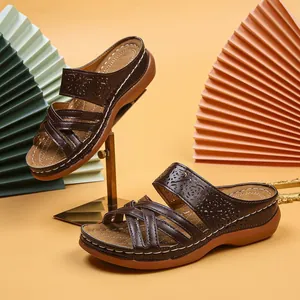 Detailed view of brown wedge sandals with decorative cutout patterns and stitching