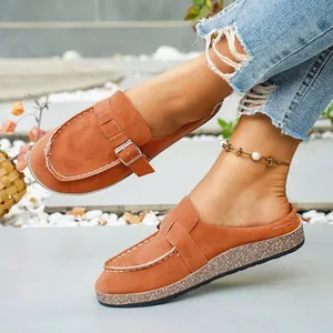 Stylish brown faux suede platform mules with metal buckle detail shown in outdoor light.