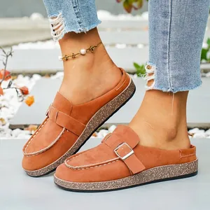 Detailed close-up of brown faux suede platform mules featuring a stylish metal buckle