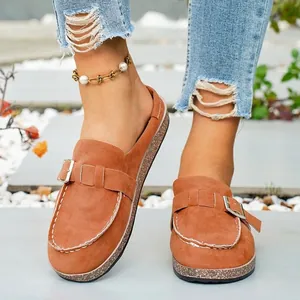 Detail view of brown faux suede platform mules with metal buckle and cork-style sole