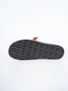 Detailed view of the anti-slip black textured outsole on a suede-style mule sandal