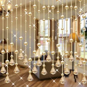 Détail d'une chaîne de perles dorées en plastique avec des pendentifs en cristal