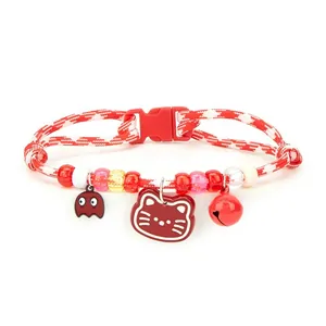 Detail view of red braided pet collar with colorful beads and cartoon cat charms
