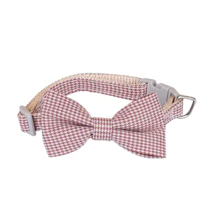 Pink houndstooth pet collar featuring an adjustable bow tie and secure plastic buckle.
