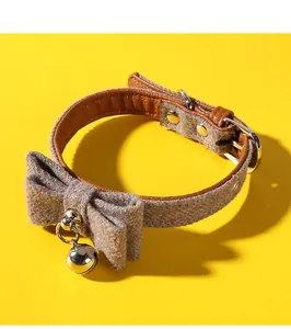 Close-up detail of the grey felt fabric cat collar with a bowknot and silver bell