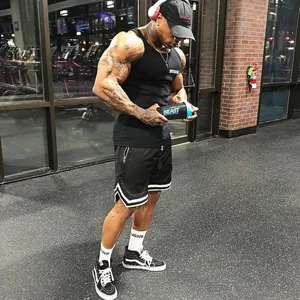 Pantaloncini da basket in mesh neri da uomo con strisce bianche in palestra.