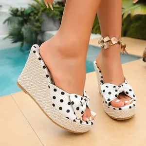 Detalle de las sandalias de cuña con lunares para mujer con lazo y plataforma de paja
