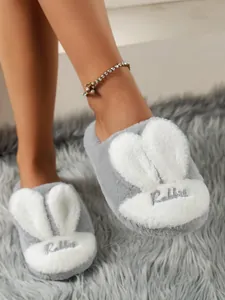 Detailed view of cozy grey fuzzy slippers with cute white rabbit ears and embroidery.