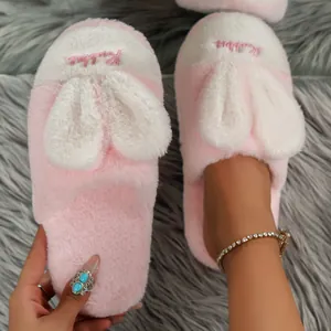 Close-up of cozy pink plush slippers featuring cute 3D bunny ears and soft fur texture
