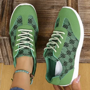 Détail de baskets vertes décontractées avec motif monogramme et semelle blanche
