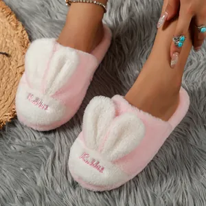 Close-up of pink plush slippers featuring cute bunny ears and Rabbit embroidery detail