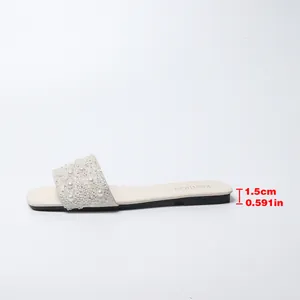 Vista dettagliata di sandali bassi da donna con perle, strass e tacco da 1,5 cm