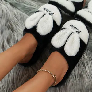 Detailed macro view of plush rabbit-head indoor slippers on a grey faux fur rug.