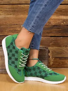 Détail de baskets vertes pour femmes avec motif monogramme noir et semelle blanche souple