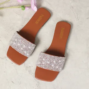 Vista dettagliata di sandali piatti da donna con perle e strass e punta quadrata