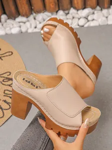 Detail view of stylish beige peep-toe high-heel sandals with platform sole.