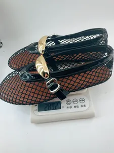 Primer plano de bailarinas de malla negra con hebilla dorada pesando en una báscula digital.