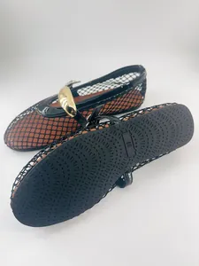 Primer plano detallado de bailarinas de rejilla negra para mujer con hebilla dorada y suela