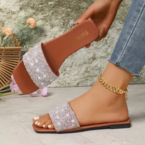 Dettaglio di ciabatte piatte da donna a punta quadrata con strass scintillanti e perle