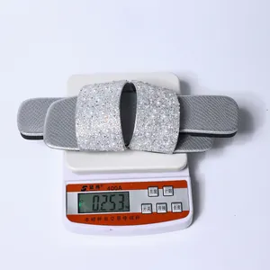 Dettaglio ravvicinato del peso delle ciabatte piatte argentate con perle e strass