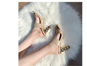 Detailansicht beige Sandalen mit hohem Absatz und einzigartigem metallischem Kürbisabsatz