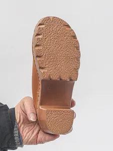 Detailed macro view showing the non-slip textured sole of a brown women's clog sandal