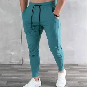 Slim fit men's teal joggers with black drawstring and cuffed ankles for gym fitness.