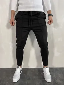 Vista dettagliata dei pantaloni fitness neri da uomo slim con cerniere alle caviglie.