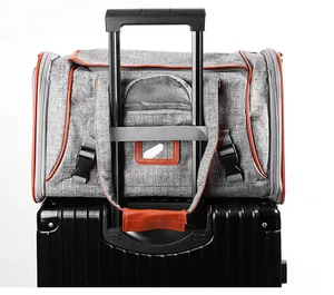 Grey pet carrier bag with trolley sleeve attached to a black suitcase handle