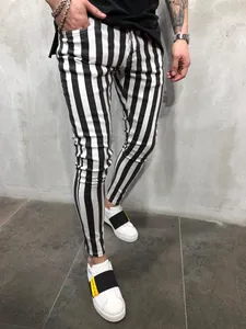 Close-up detail of men's black and white vertical striped skinny fitness running pants
