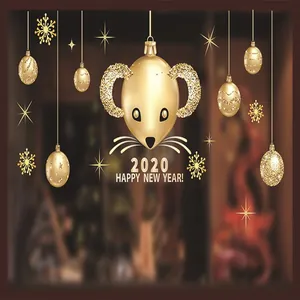 Detalle de pegatinas navideñas doradas de ratón y bolas con texto de Feliz Año Nuevo.