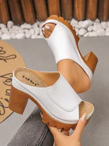 Detail view of white peep toe platform sandals with chunky brown heels and lug soles