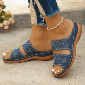 Vue détaillée de l'élégant motif floral ajouré bleu sur les sandales compensées pour femmes