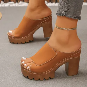 Close-up of tan chunky platform mules with peep toe and white stitching details