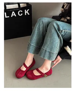 Scarpe Mary Jane in pelle scamosciata rossa con cinturino abbinate a jeans in denim.