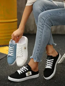 Detail van drie kleuren dames canvas mules in zwart, blauw en wit met gerafelde randen
