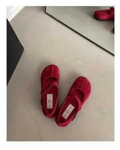 Dettaglio di scarpe Mary Jane rosse in pelle scamosciata con cinturino a fibbia