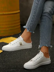Close-up van stijlvolle witte canvas muiltjes met gerafelde randen en vetersluiting