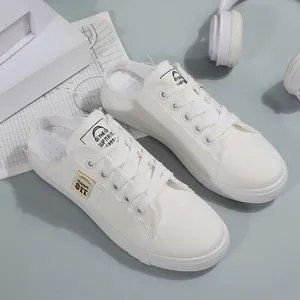 Gedetailleerd overzicht van witte canvas slip-on sneakers met gerafelde randen en veters