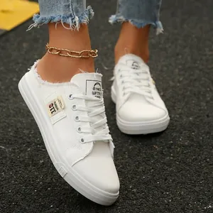 Stijlvolle witte canvas slip-on sneakers voor dames met gerafelde randen en witte veters.