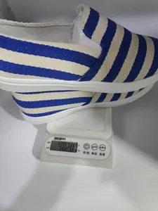 Detailweergave van gestreepte canvas loafers die een gewicht van 482g tonen op een weegschaal
