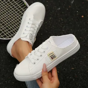 Detailweergave van witte canvas mules met ademend materiaal en de zachte zool