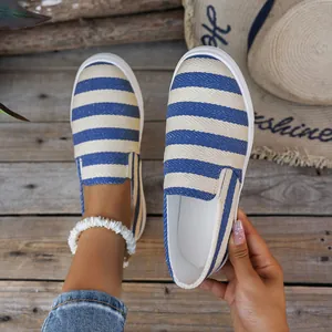 Detailweergave van blauw-wit gestreepte canvas slip-on vrijetijdsschoenen voor dames.